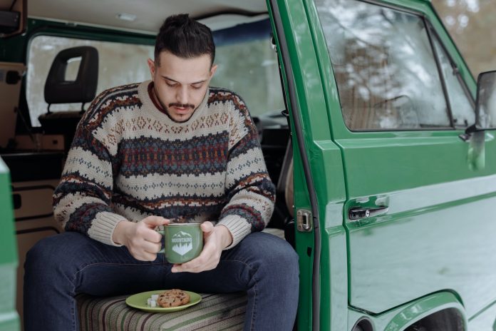 a man having coffee while sitting in a van